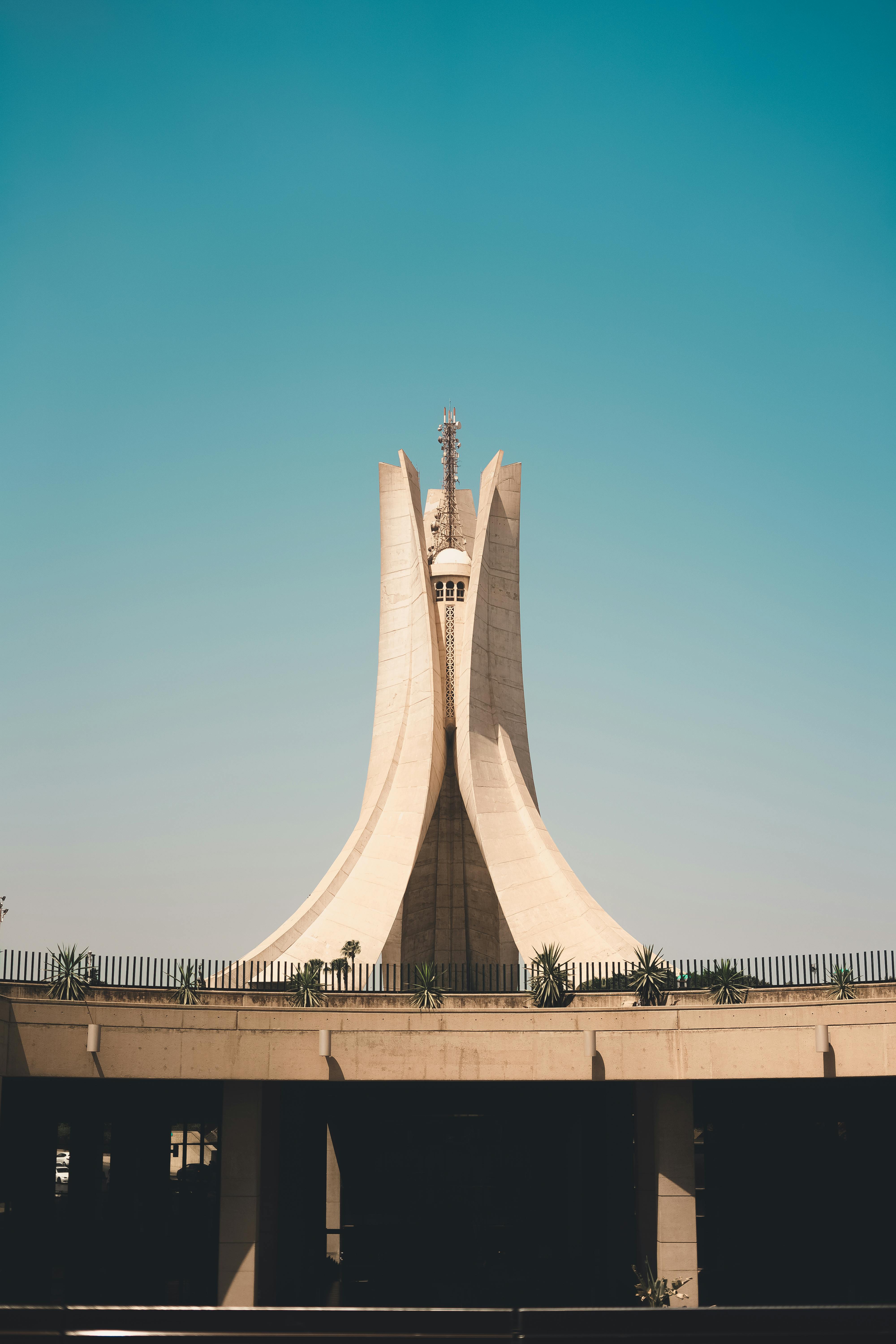 The Martyrs' Memorial, an iconic concrete monument with four curved pillars, under clear blue sky.